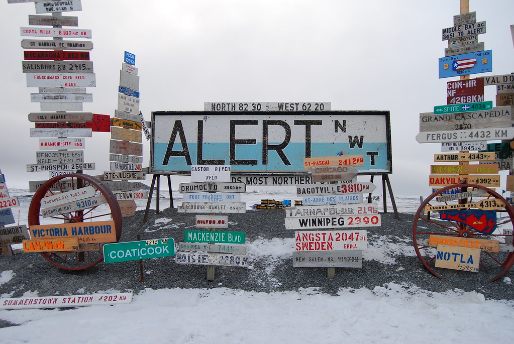 an image of alert, canada that has a big sign of the name and multiple signs